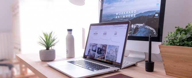 MacBook Pro on table beside white iMac and Magic Mouse